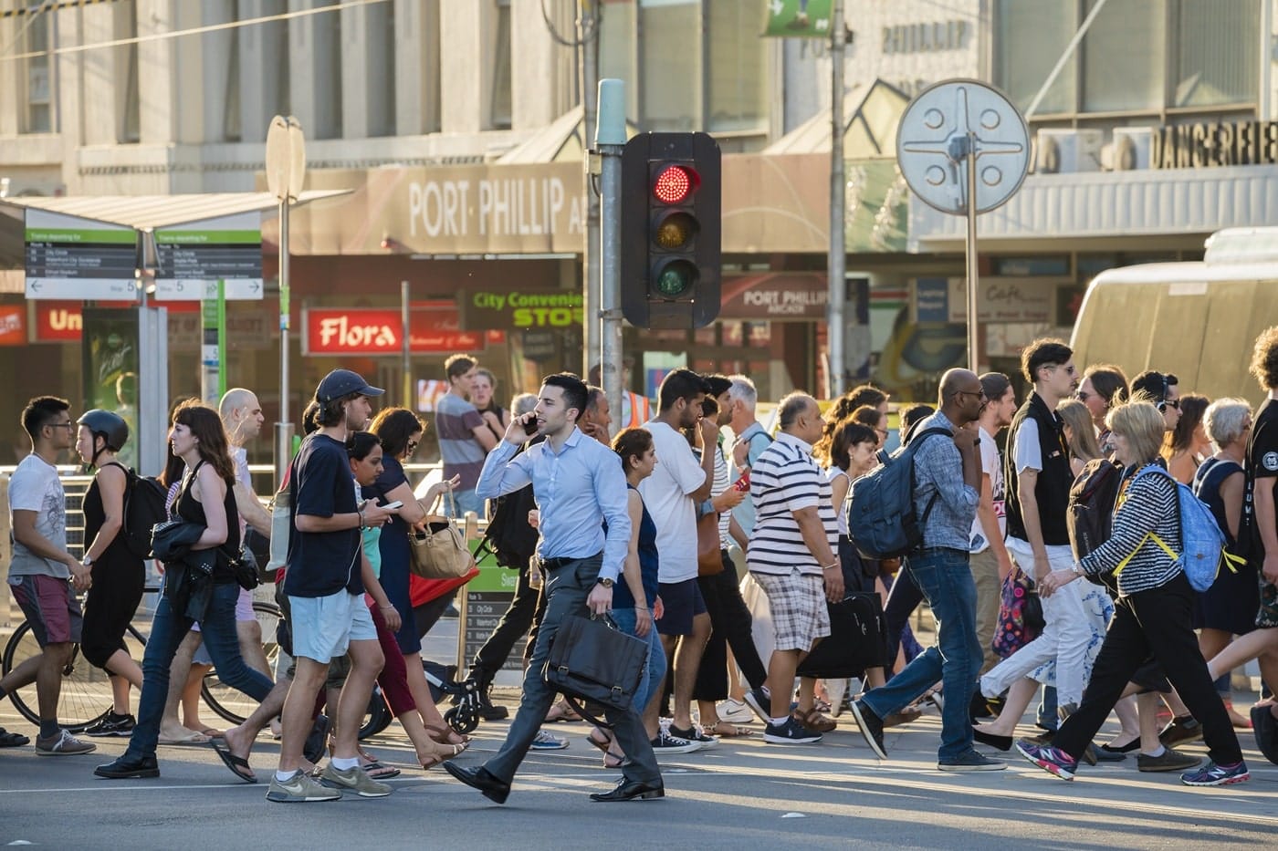 general-public-using-busy-crosswalk-to-go-to-work General public crossing busy street, illustrating regional engagement and diverse community movement.